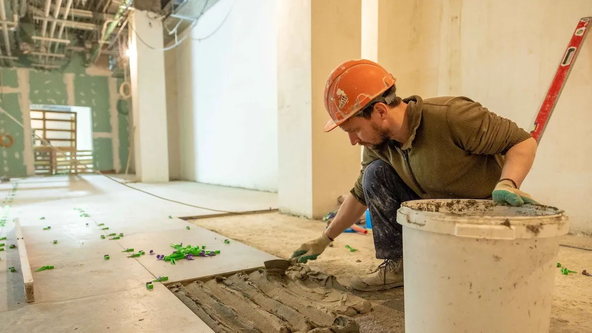 Fliesenleger verlegt Fliesen auf einer Baustelle